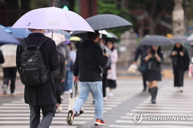 비 내리는 서울 (서울=연합뉴스) 서대연 기자 = 비가 내린 22일 오전 서울 종로구 광화문네거리에서 시민들이 우산을 쓰고 길을 건너고 있다. 2024.10.22 dwise@yna.co.kr