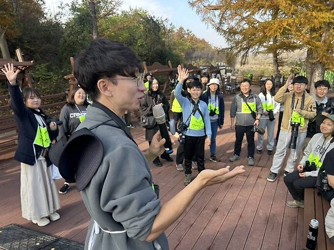 지난 15일 민간인통제구역인 경기도 파주시 임진강변 생태탐방로에서 유튜버 크리에이터 ‘새덕후’ 김어진씨(맨앞 회색 옷)가 시민 50여 명이 참여하는 야생 조류 탐조 프로그램을 진행하고 있다. 경기광관공사 제공