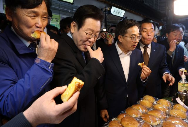 이재명(왼쪽 두번째) 더불어민주당 대표가 21일 오전 경기도 수원 못골종합시장에 있는 한 빵집에서 빵을 시식하고 있다. 이 대표 오른쪽은 김동연 경기도지사. 연합뉴스