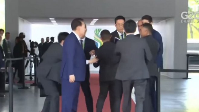 윤석열 대통령을 뒤따르던 통역요원이 현지 경호원들에게 입장을 제지를 당해 실랑이를 벌이는 모습이 영국 한 방송사 카메라에 잡혔다. [사진= MBC 캡처]