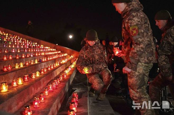 [키이우=AP/뉴시스]전쟁 발발 1000일을 맞은 지난 19일 우크라이나 키이우에서 열린 전몰자 추모식에서 우크라이나 군인들이 촛불을 밝히고 있다. 3년 가까이 이어지는 러시아와의 전쟁에 대한 염증이 점점 더 강해지면서 가능한 한 빨리 전쟁을 끝내기 위해 영토 양보를 포함하더라도 러시아와 협상해야 한다는 우크라이나 국민들이 절반을 넘긴 52%에 달한 것으로 지난 8월과 10월 갤럽이 실시한 여론조사에서 나타났다. 2024.11.21.