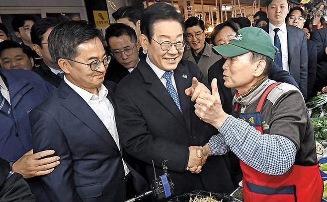 이재명, 김동연과 함께 수원 시장 찾아 - 더불어민주당 이재명 대표가 21일 경기 수원시 팔달구 못골종합시장에서 민주당 소속 김동연(왼쪽 끝) 경기지사와 함께 상인과 대화를 나누고 있다. 김 지사는 이 대표의 일부 정책 노선에 대해 반대 의견을 밝혔었지만, 이날 이 대표와 민생 현장 탐방을 함께했다. /고운호 기자