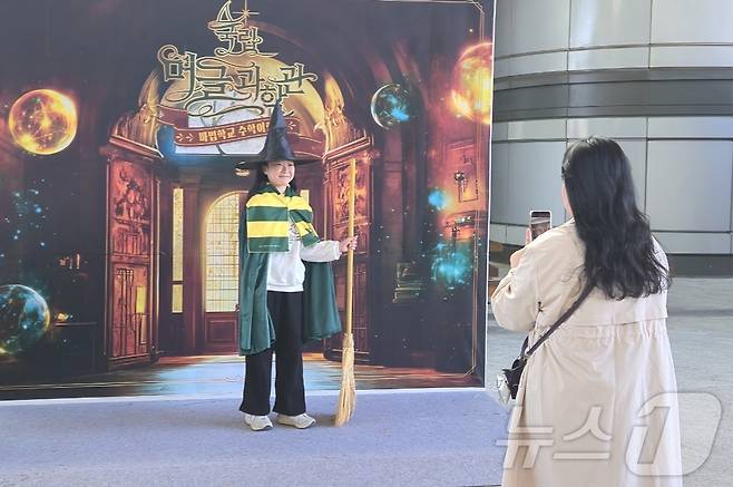 24일 대전 유성구 국립중앙과학관에서 '마법학교 수학여행'에 참가한 한 어린이와 학부모가 포토존에서 기념사진을 찍고 있다. 2024.11.24 /뉴스1 ⓒ News1 허진실 기자