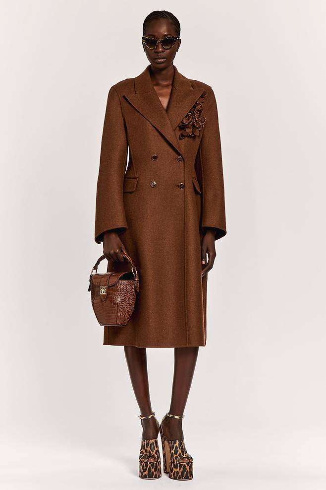 가슴 부분의 탈부착 가능한 3D 플라워 장식이 특징인 더블 브레스티드 테일러드 코트. 에르마노 설비노.