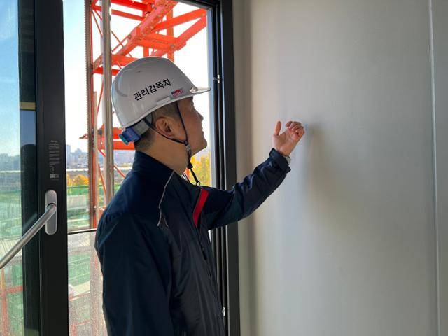 SK에코플랜트 직원이 청계SK뷰 아파트 발코니 벽을 두드리고 있다. 건설사들은 일반적으로 발코니에는 단열재를 시공하지 않는데 이 아파트는 서울주택도시공사(SH) 기준에 따라 단열재를 설치했다. 김민호 기자