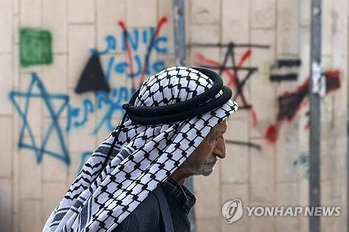 유대인 정착촌 근처 이스라엘군 초소 지나는 팔레스타인 노인 (서안지구 베이트로마노 AFP=연합뉴스) 2024년 11월 23일 요르단강 서안지구 내 베이트로마노 유대인 정착촌 근처 이스라엘군 초소의 담벼락 앞을 한 팔레스타인 노인이 지나가고 있다. 2024.11.24.