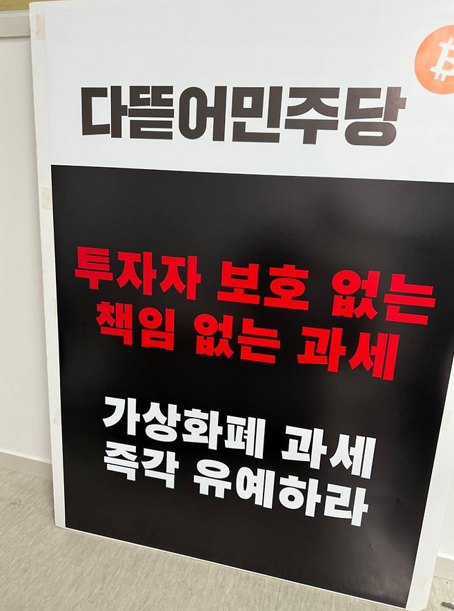 또 다른 KOL도 "다뜯어민주당(더불어민주당을 비판하는 말)은 투자자 보호 없는 책임 없는 과세를 그만두고 가상화폐(가상자산) 과세를 즉각 유예하라"는 문구가 담긴 피켓을 들고 민주당사 앞에서 1인 시위를 진행할 것이라 예고했다. 가상자산 커뮤니티 갈무리.