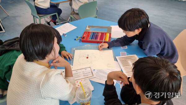 지난 24일 오후 슬기샘어린이도서관 트윈웨이브 공간에서 진행된 ‘평온한 한 해’ TRPG 프로그램의 참여자들이 자신만의 세계관이 담긴 마을을 그려가고 있다. 이나경기자