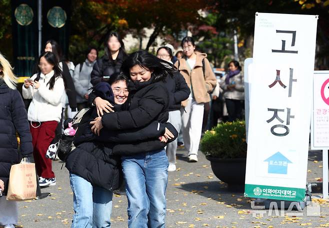 [서울=뉴시스] 전신 기자 = 23일 서울 서대문구 이화여자대학교에서 열린 2025학년도 수시모집 논술고사를 마친 한 수험생이 친동생의 격려를 받으며 고사장을 나서고 있다. 2024.11.23. photo1006@newsis.com