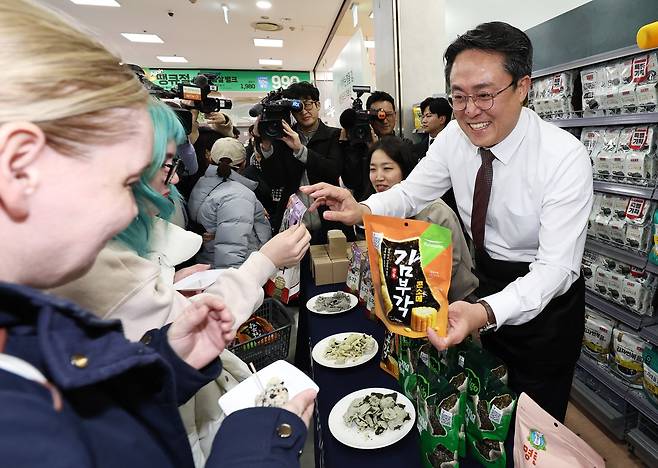 강도형 해양수산부 장관이 26일 오후 서울 중구 롯데마트 제타플렉스 서울역점에서 김 수출액 역대 최고기록 경신을 기념해 관광객들에게 김으로 만든 주먹밥과 김부각을 나눠주고 있다. 뉴스1