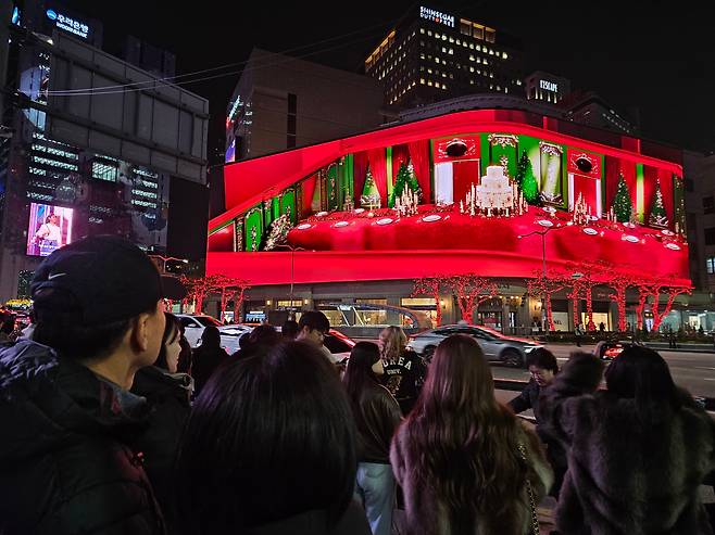 11월 25일 서울 중구 신세계백화점 본점 건너편에서 많은 시민들과 관광객들이 대형 디스플레이에 펼쳐지는 크리스마스를 주제로한 영상을 보고 있다./ 전기병 기자