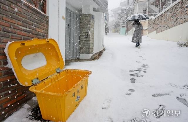 수도권에 폭설이 내린 27일 오전 수원시 팔달구 한 제설함이 비어있어 제설이 안된 골목길을 시민이 조심스레 걷고 있다. 윤원규기자