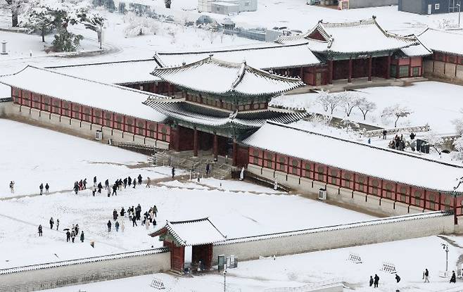 서울 지역에 폭설이 내린 27일 오전 서울 종로구 경복궁에서 시민들이 산책을 즐기고 있다. 연합뉴스 제공