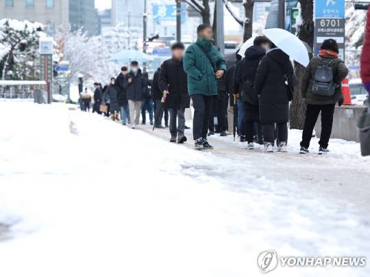 이틀 연속 폭설이 내린 28일 오전 서울 중구 세종대로 일대에서 시민들이 출근하고 있다. [사진=연합뉴스]