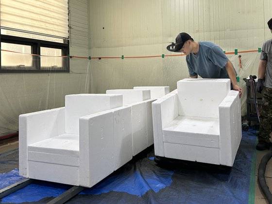 쉽게 부서지고 속이 텅 빈 스티로폼 상자를 부서지지 않는 의자로 만들기 위해 ‘산업용 열경화성 합성수지 코팅’이라는 기법이 이용됐다. 지난 9월 김씨가 코팅을 하기 위해 폐스티로폼 의자를 옮기고 있는 모습. 사진 김하늘 디자이너