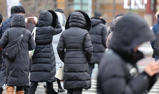 People wearing long padded jackets walk a street in Jongno District, central Seoul, on Jan. 22. [NEWS1]
