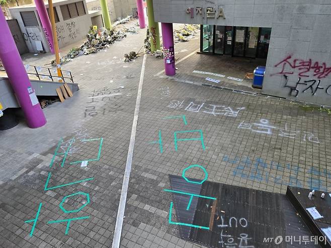 26일 예지관 외벽과 보도블록에 래커로  '공학out' '민주동덕' 등이 쓰여있다. 한 켠에 래커 3통이 여전히 남아있다/사진=이혜수 기자