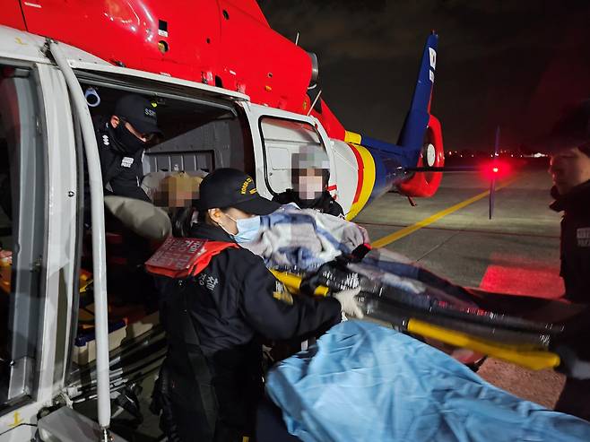 동해해경청 소속 경찰관이 지난 5일 울릉도에서 뇌출혈 의심증상을 보인 60대 응급환자를 헬기에 탑승시키고 있다. /뉴스1