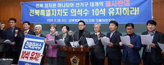전북특별자치도의회 더불어민주당 의원들이 지난 2월 28일 전북 전주시 전북특별자치도의회에서 '전북 의석 10석 사수' 기자회견을 열고 구호를 외치고 있다. 뉴스1