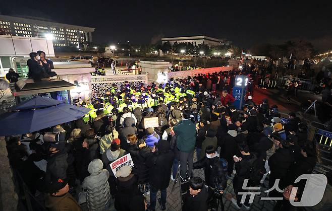 윤석열 대통령의 비상계엄 해제 요구 결의안이 국회 본회의에서 통과된 4일 새벽 서울 여의도 국회 정문 앞에 모인 시민들이 윤 대통령을 규탄하고 있다. 여야는 이날 본회의에서 재석 190명 중 찬성 190명으로 비상계엄 해제 요구 결의안을 가결 처리했다. 이에 따라 계엄령 선포는 무효가 됐다고 국회의장실은 설명했다. 2024.12.4/뉴스1 ⓒ News1 장수영 기자