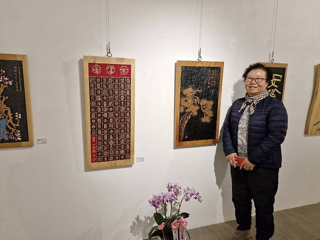 ▲자신의 작품 앞에서 포즈를 취한 신영철 작가