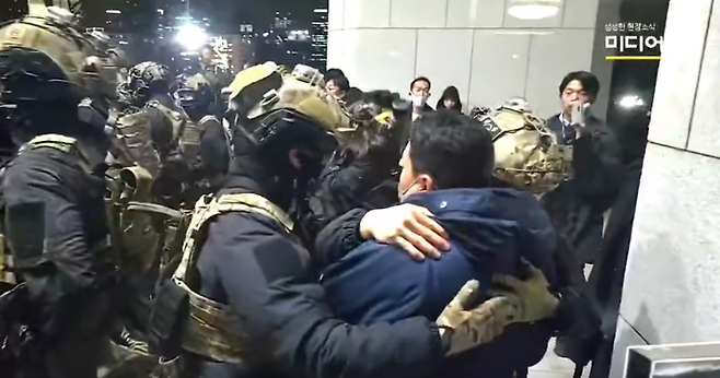 4일 서울 여의도 국회에서 비상계엄에 항의하는 시민을 계엄군이 끌어안아 진정시키고 있다. 미디어몽구 영상 갈무리