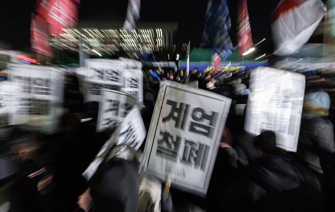 윤석열 대통령의 비상계엄 해제 요구 결의안이 국회 본회의에서 통과된 4일 새벽 서울 여의도 국회 정문 앞에 모인 시민들이 모여 있다.   여야는 이날 본회의에서 재석 190명 중 찬성 190명으로 비상계엄 해제 요구 결의안을 가결 처리했다. 이에 따라 계엄령 선포는 무효가 됐다고 국회의장실은 설명했다. /사진=뉴스1
