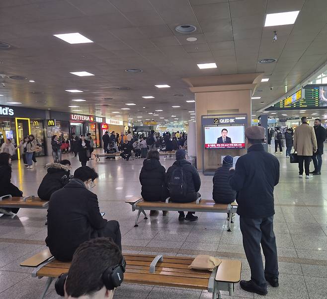 윤석열 대통령의 ‘비상계엄’이 해제된 4일 오전 서울역 에서 시민들이 계엄 관련 뉴스를 시청하고 있다. 윤 대통령은 3일 오후 10시30분께 비상계엄을 선포했고, 이후 6시간여만인 이날 오전 국무회의를 열고 비상계엄을 해제 한다고 밝혔다. [김도윤 기자]