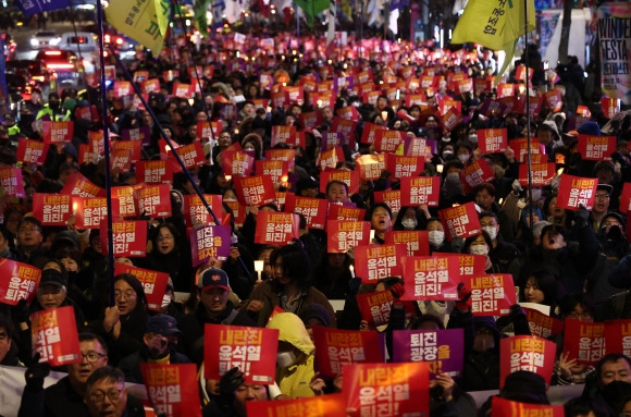 윤석열 대통령 퇴진 촉구하며 행진하는  참석자들 - 4일 오후 서울 동화면세점 앞에서 열린 ‘내란죄 윤석열 퇴진! 시민촛불’에서 전국민주노동조합총연맹 조합원을 비롯한 참석자들이 용산 대통령실 방향으로 행진하고 있다. 연합뉴스