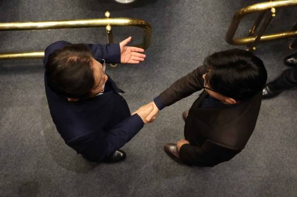 윤석열 대통령이 긴급 대국민 담화를 통해 비상계엄령을 발표한 가운데 4일 새벽 서울 여의도 국회 본회의장에서 한동훈 국민의힘 대표와 이재명 더불어민주당 대표가 악수하고 있다. 2024.12.4 뉴시스