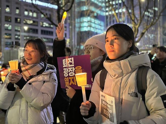 12월5일 서울 광화문역 인근에서 열린 '윤석열 퇴진 시민대회'에 참여한 대학생 이아무개씨(25)와 친구들이 촛불을 들고 있다. ⓒ시사저널 정윤경