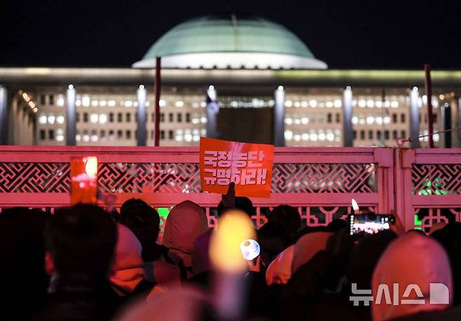 [서울=뉴시스] 정병혁 기자 = 7일 서울 영등포구 국회 앞에서 열린 '내란죄 윤석열 퇴진! 국민주권 실현! 사회대개혁! 국민촛불대행진'에서 시민들이 윤석열 대통령 탄핵안 개표 결과를 확인한 뒤 피켓을 들고 있다. 2024.12.07. jhope@newsis.com