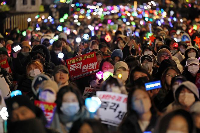 8일 저녁 서울 여의도 국회 앞에서 열린 윤석열 탄핵 및 구속을 촉구하는 촛불문화제에서 참가자들이 관련 손팻말과 응원봉을 들고 있다. 연합뉴스