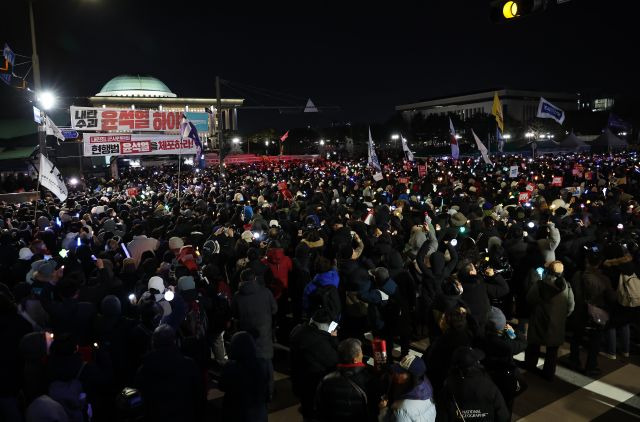 7일 오후 서울 여의도 국회 앞에서 열린 '내란죄 윤석열 퇴진! 국민주권 실현! 사회대개혁! 범국민촛불대행진'에서 참가자들이 탄핵안 표결 처리를 촉구하고 있다. 연합뉴스