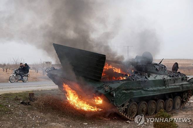 불타는 시리아 정부군 장갑차 (AFP 연합뉴스) 7일(현지시간) 시리아 중부 하마 지역의 한 도로에 정부군 장갑차가 불타는 채로 버려져 있다. 2024.12.07 photo@yna.co.kr