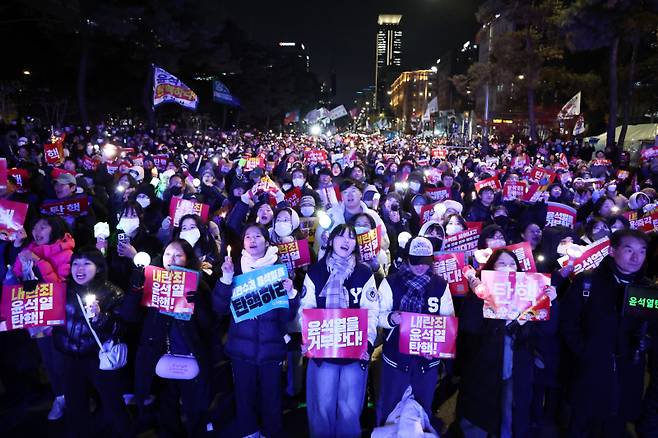 지난 7일 오후 서울 여의도 국회 앞에서 열린 '내란죄 윤석열 퇴진! 국민주권 실현! 사회대개혁! 범국민촛불대행진'에서 참석자들이 관련 손 피켓을 흔들고 있다. 사진=연합뉴스 