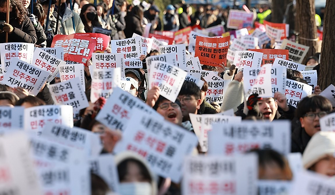 7일 오후 서울 영등포구 여의도 산업은행 본점 인근에서 열린 '윤석열 퇴진 대학생 시국대회'에서 대학생들이 비상계엄을 선포한 대통령의 퇴진을 촉구하며 손팻말을 흔들고 있다. 사진 연합뉴스