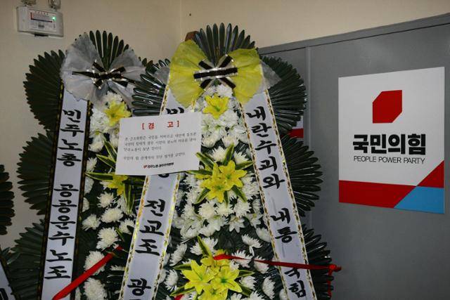 9일 오후 광주 서구 치평동 국민의힘 광주광역시당 앞에 민주노총이 보낸 탄핵 표결을 거부한 국민의힘을 규탄하는 내용의 근조 화환이 놓여져 있다. 뉴스1