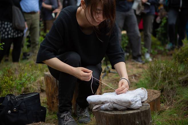 2019년 5월 한강 작가가 퓨처 라이브러리에 보낼 원고를 ‘퓨처 라이브러리 숲’에서 보내는 흰 천으로 묶는 모습. 이 원고는 2114년 공개된다. [Kristin von Hirsch·Anne Beate Hovind]