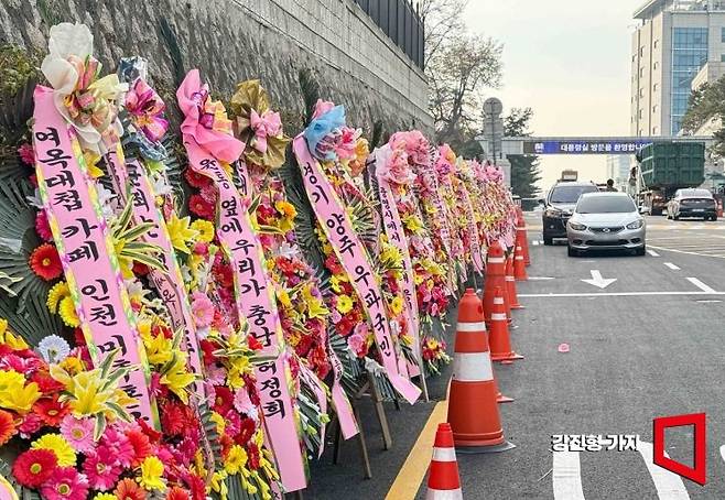 국회가 오는 14일 윤석열 대통령 탄핵안 재표결을 앞둔 가운데 11일 서울 용산구 대통령실 정문으로 올라가는 길 담벼락에 대통령을 응원하는 화환이 놓여 있다. 강진형 기자