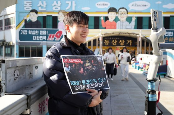 지난 10일 오후 대구 중구 서문시장 육교 위에서 한 청년 유튜버가 매일 저녁 대구에서 열리는 윤석열 퇴진 촉구 집회를 안내하고 있다. 뉴스1