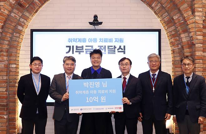 Park Jin-young, center, during a handover ceremony held on Dec. 10 at JYP Entertainment’s headquarters in Seongdong District, eastern Seoul. [JYP ENTERTAINMENT]