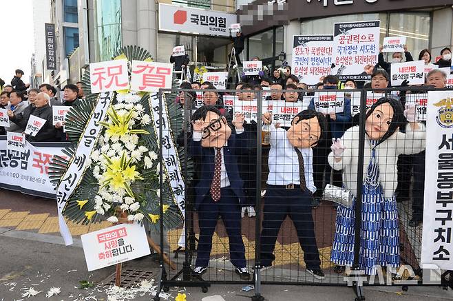 [울산=뉴시스] 배병수 기자 = 11일 오전 울산시 남구 국민의힘 울산시당 앞에서 열린 내란공범 국짐당 장례식에서 참가자들이 윤 대통령과 김건희여사가 구속되는 퍼포먼스를 하고 있다. 2024.12.11.bbs@newsis.com.