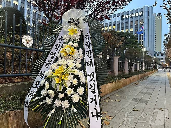 12일 오후 서울 서대문구 미근동 경찰청사 정문 인근 울타리에는 "윤석열을 체포하라, 검찰한테 뺏길거냐" 내용이 담긴 근조화환이 설치됐다.