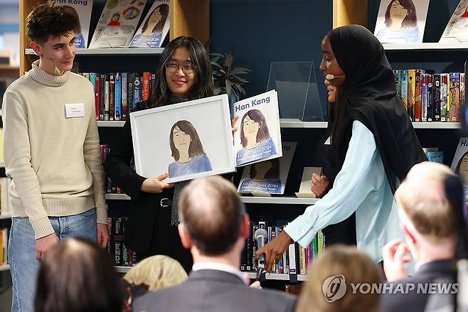 초상화와 기념책자 받은 한강 작가 (스톡홀름=연합뉴스) 김도훈 기자 = 2024 노벨문학상 수상자인 한강 작가가 11일(현지시간) 스웨덴 스톡홀름 외곽에 위치한 린케뷔 도서관에서 열린 노벨문학상 기념책자 낭독회에서 초상화와 기념 책자를 선물로 받고 있다. 2024.12.11 superdoo82@yna.co.kr