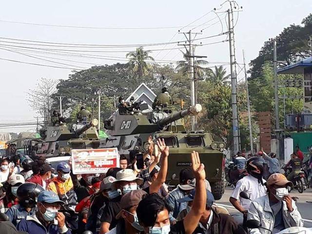 2021년 2월 미얀마 양곤에서 북쪽으로 3시간 거리인 따웅우에 등장한 장갑차 앞에서 시민들이 저항을 상징하는 세 손가락을 들어올리며 항의하고 있다. 한국일보 자료사진