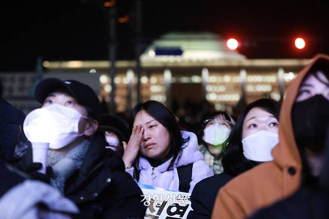 윤석열 대통령에 대한 탄핵소추안 표결이 진행된 7일 저녁 서울 여의도 국회 앞에서 열린 집회에 참석했던 한 시민이 우원식 국회의장이 투표 종료를 선언하자 눈물을 흘리고 있다. 2024.12.7 이준헌 기자