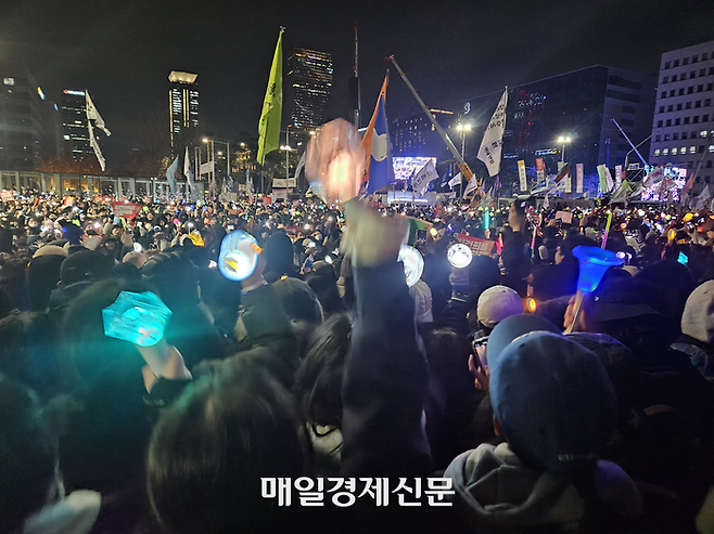 7일 국회 앞에서 열린 윤석열 대통령 탄핵 촉구 집회에서 일부 참가자들이 LED 촛불 대신 아이돌 응원봉을 들어보이고 있다. [지혜진 기자]