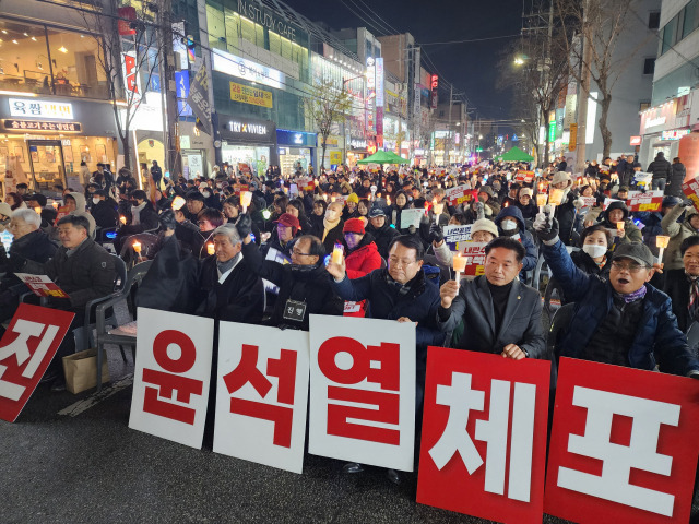 ▲13일 익산시 영등2동 행정복지센터 앞에서 시민들은 '윤석열 탄핵'과 '국민의힘 해체'를 외치며 촛불로 어둠을 밝혔다. 행사장은 촛불을 든 시민들로 가득 찼고 정헌율 익산시장과 김경진 익산시의회 의장도 함께 촛불을 들었다. ⓒ프레시안