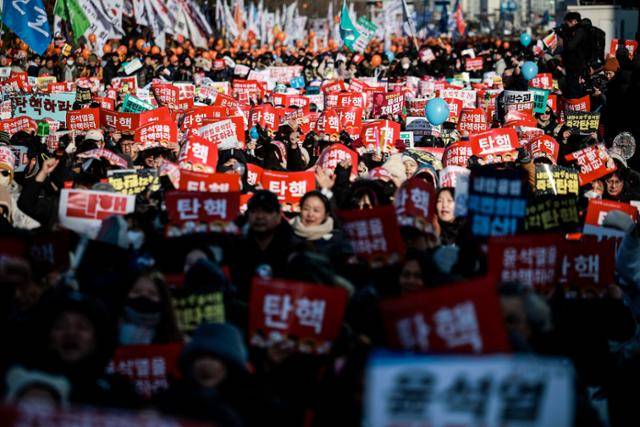 14일 서울 영등포구 국회 앞에서 열린 '내란수괴 윤석열 즉각탄핵' 범국민 촛불대행진에 참가한 시민들이 피켓을 들고 있다. 뉴시스